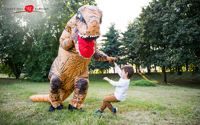 Person in an inflatable T-Rex costume playing with child.